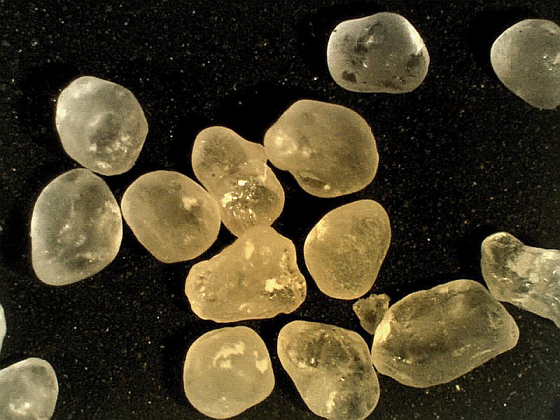 Well rounded (smoothed) mineral grains. The degree to which the grains are rounded can tell us how far they have been transported: the more rounded they are, the further they have traveled. rounded quartz grains
